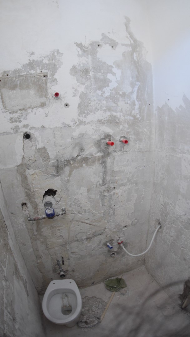 Old bathroom wall with tiles removed